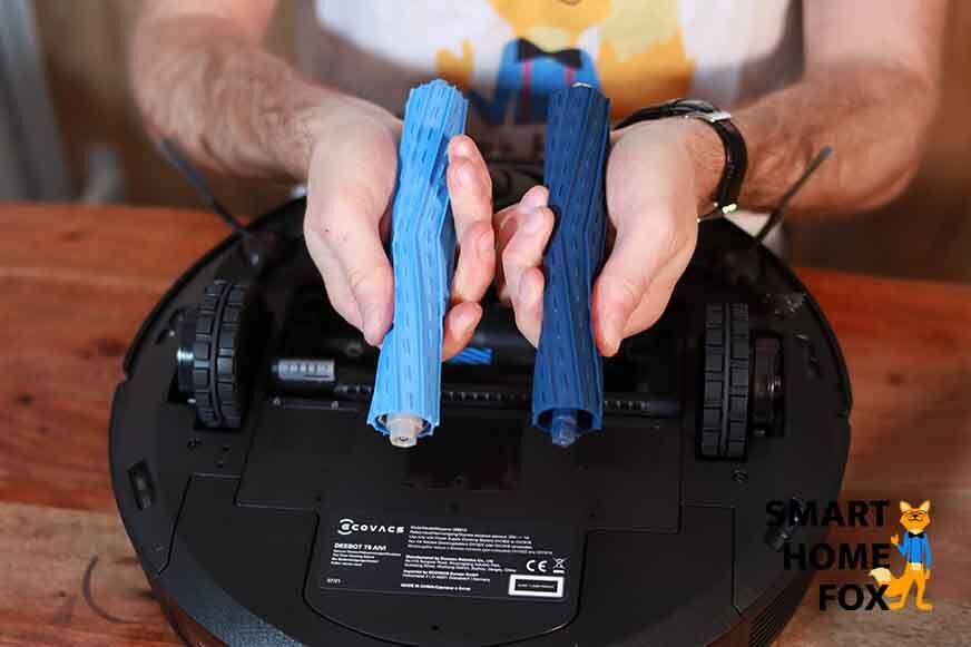 Die beiden blauen Gummiwalzen des Ecovacs Deebot T9 AIVI werden aus der Bürstenhalterung gelöst